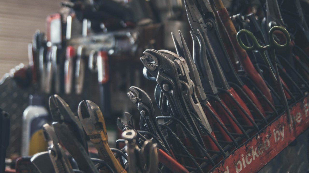 Organized plumbing tools and wrenches arranged on a workbench, representing a professional plumbing service business