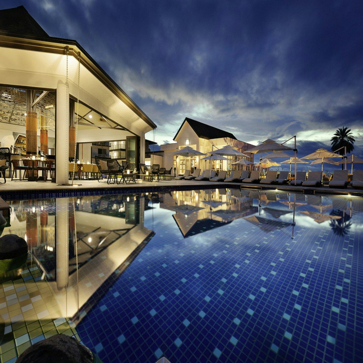 Warm-lit boutique hotel lobby with a clean reception desk and soft ambient lighting